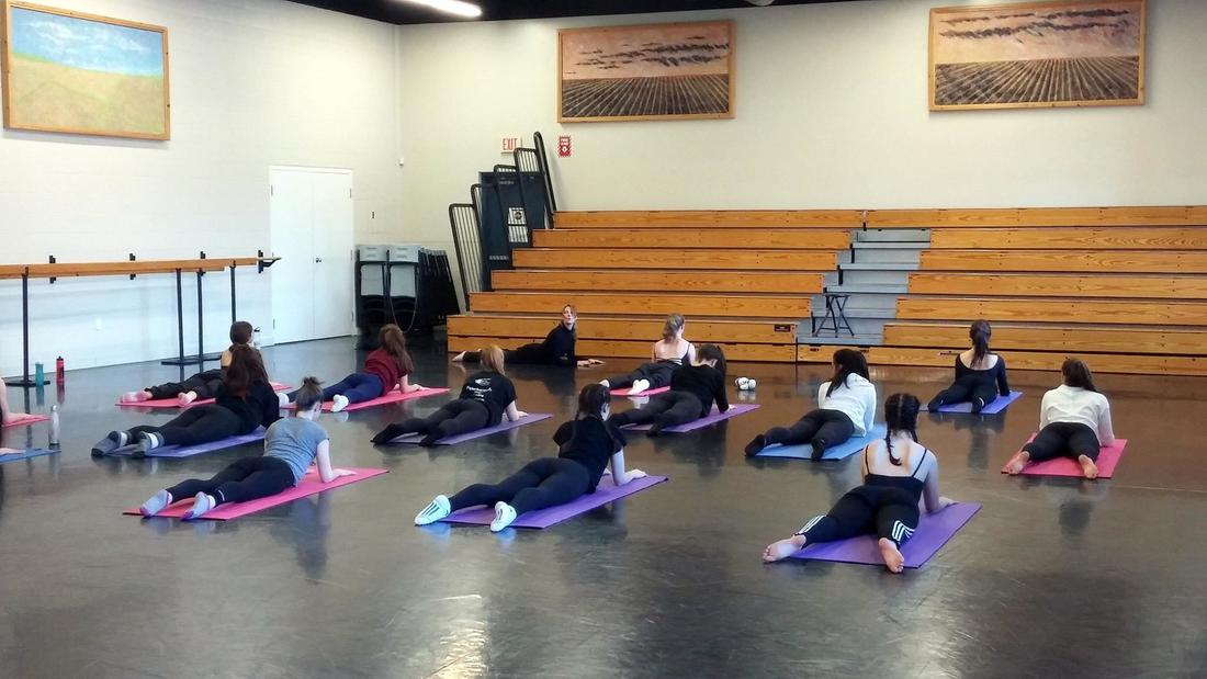 A picture of Andrea instructing a group of dance students